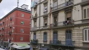 A street view with multi-story buildings, balconies with laundry, and parked cars. - Donn'Anna Bed & Breakfast (Naples)