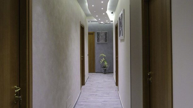 A hallway with wooden doors, recessed lighting, and a tiled floor. - Donn'Anna Bed & Breakfast (Naples)
