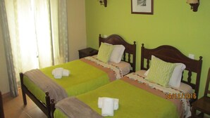 A room with two beds, a nightstand, a lamp, and a framed picture on the wall. - Guest House Capitão Mor (Faro)
