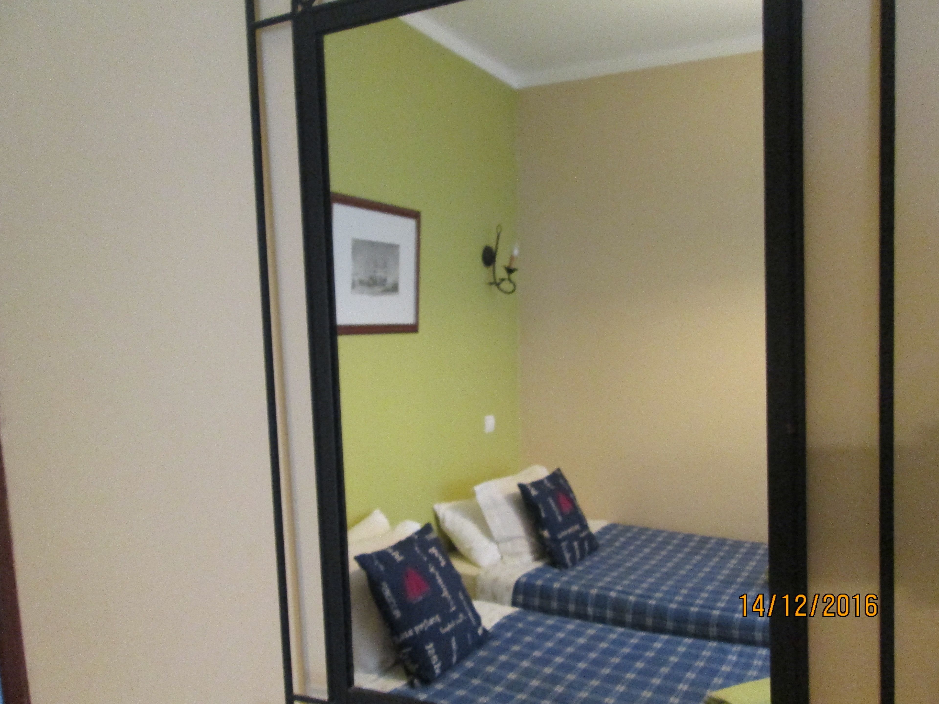 Una habitación con dos camas, un cuadro en la pared y un sello de fecha.