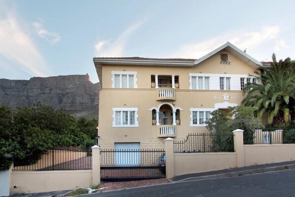 A two-story building with a balcony, a garage, and a gate.