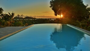 Vista despejada de una piscina con el atardecer al fondo.