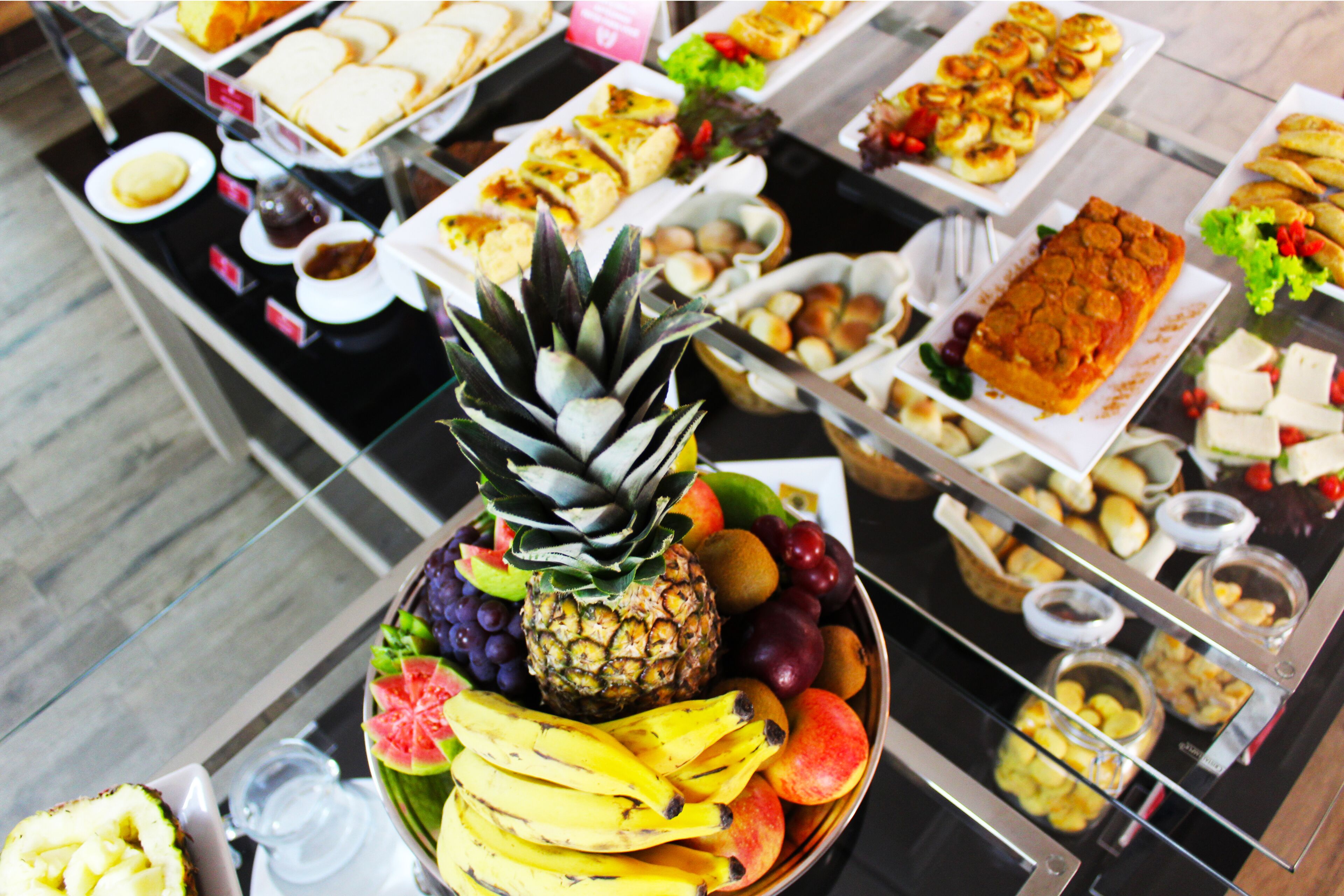 A buffet with various food items including fruits, pastries, and desserts.