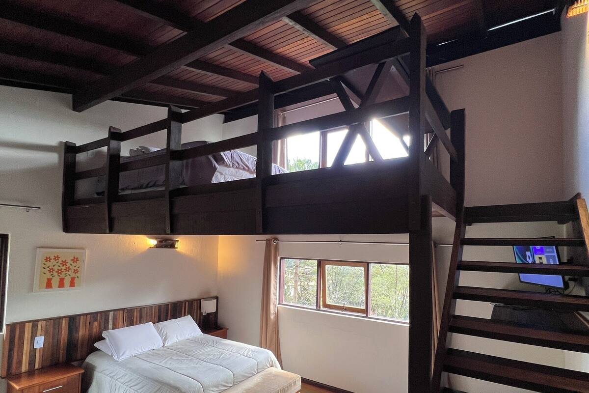 Une chambre avec un lit superposé, un bureau et un ordinateur.