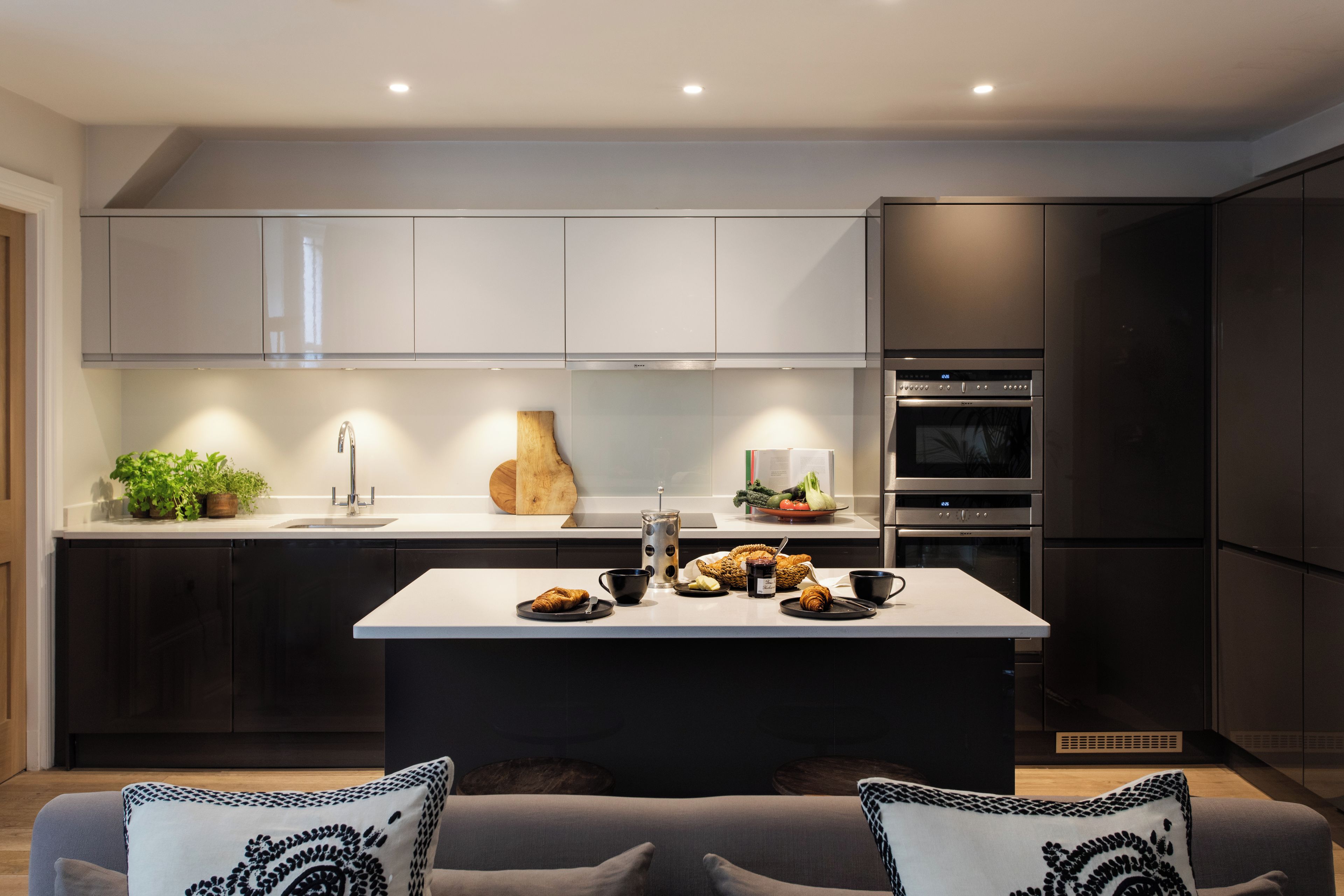 Una cocina moderna con una isla central, electrodomésticos de acero inoxidable y un diseño minimalista.