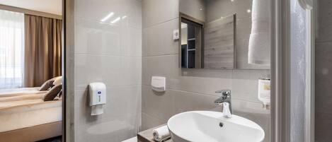 Et moderne badeværelse med en stor vask, toilet og et spejl.
