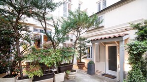 A courtyard with potted plants and a building entrance. - MHL - Maison Hotel Lyon (Lyon)