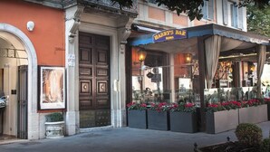 A bar named Harry's Bar with a classic facade, large wooden doors, and flower boxes in front. - The Shire Hotel (Rome)