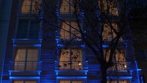 A hotel with a modern facade, illuminated blue lighting, and a visible reception area with seating. - Sinopark Otel (Sinop)