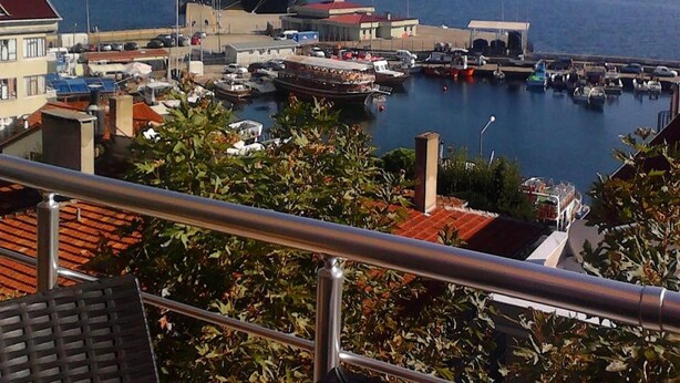 A harbor with a large cruise ship docked, surrounded by buildings and boats. - Sinopark Otel (Sinop)