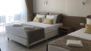 A hotel room with two beds, a large window with curtains, and a view of the city. - Sinopark Otel (Sinop)