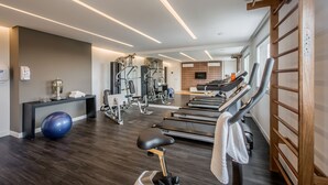 Une salle de sport moderne équipée de tapis de course, de ballons d’exercice et d’appareils de musculation.