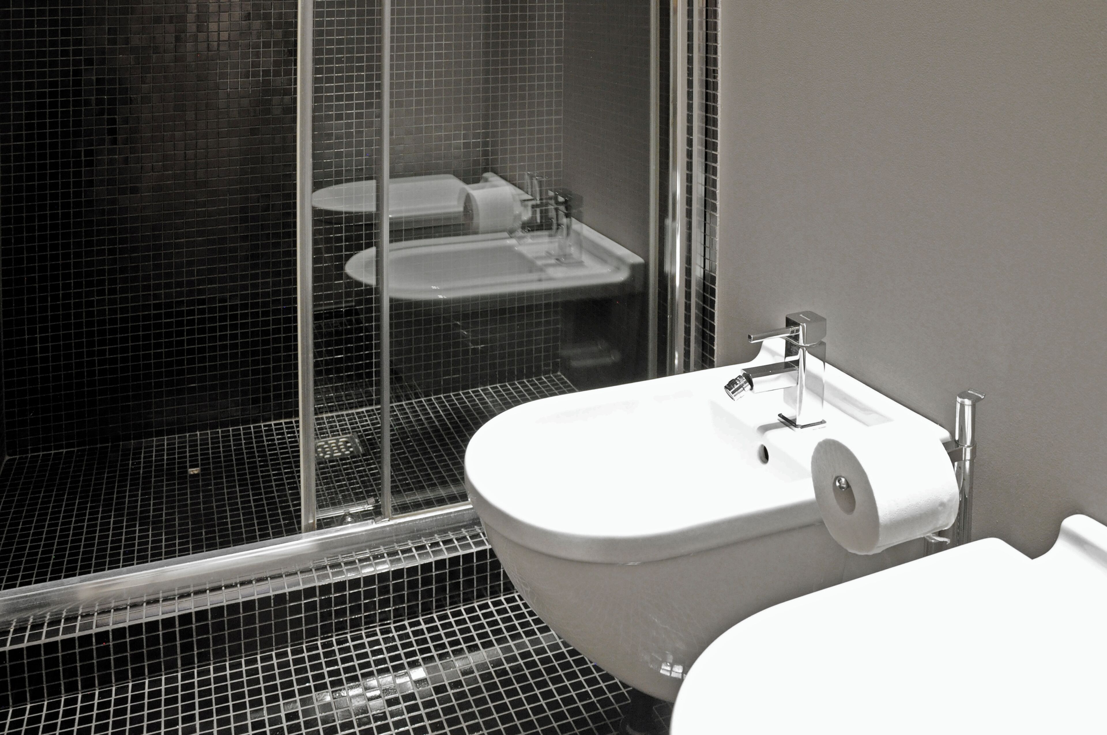 Un baño con lavamanos blanco, inodoro y cabina de ducha de vidrio.