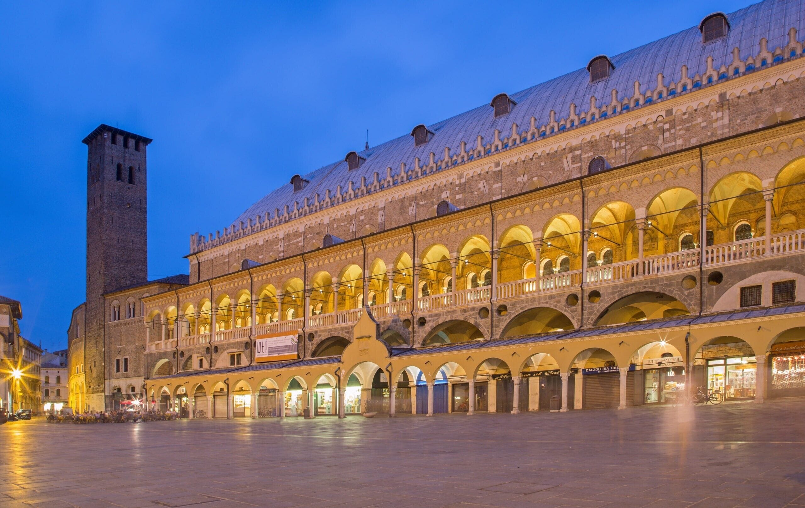 A historic building with a prominent tower and a series of arches.