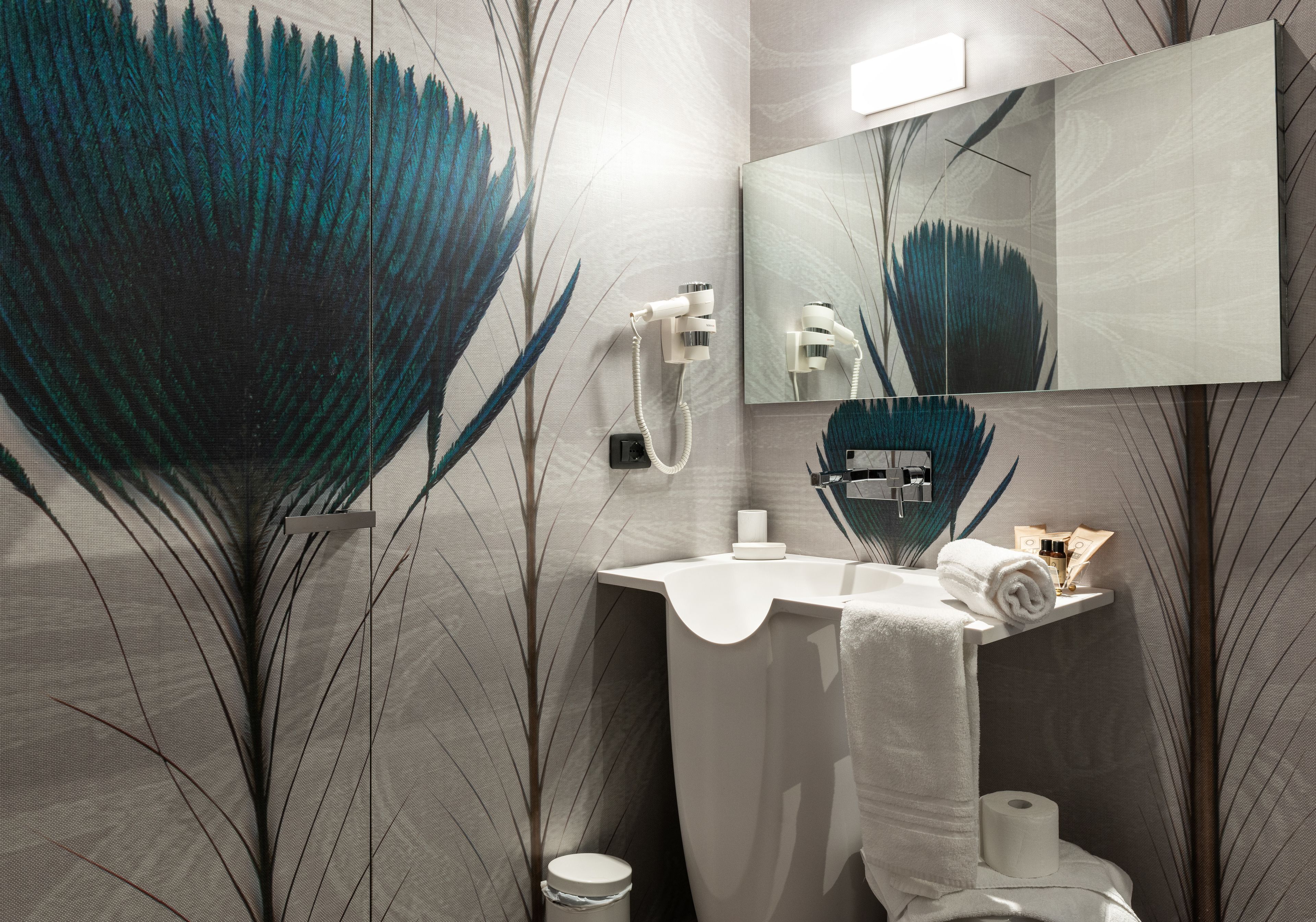 Un baño de diseño moderno, con un espejo grande, un lavamanos y un inodoro.