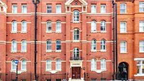 A red brick building with multiple windows and a central entrance labeled "Cleveland Residences." - One Bed Serviced Apts near Oxford Street (London)