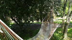 Een hangmat tussen bomen in een weelderige tuin.
