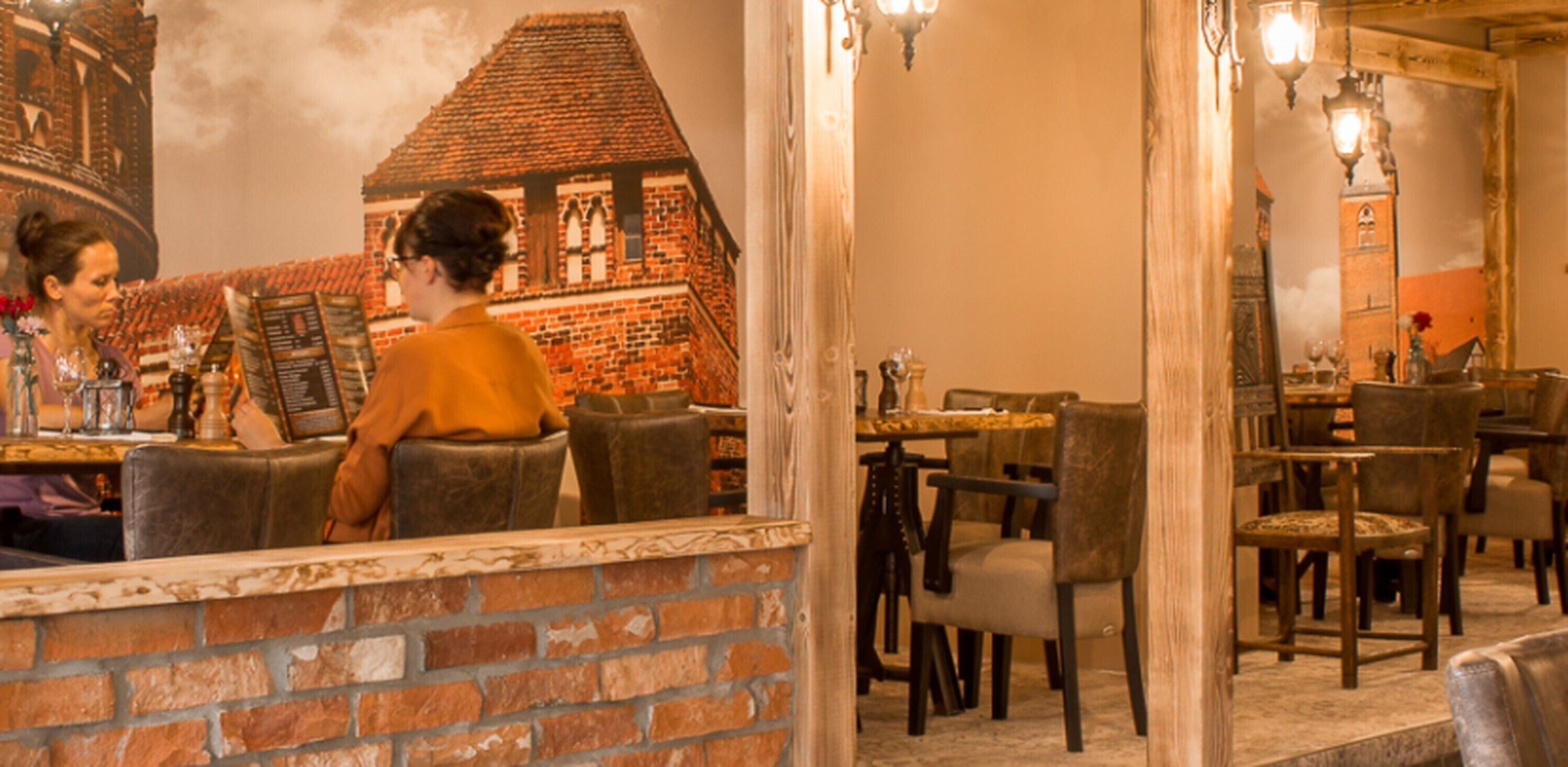 Un interior de restaurante con paredes de ladrillo, mesas y sillas de madera.
