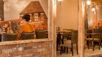 Un interior de restaurante con paredes de ladrillo, mesas y sillas de madera.