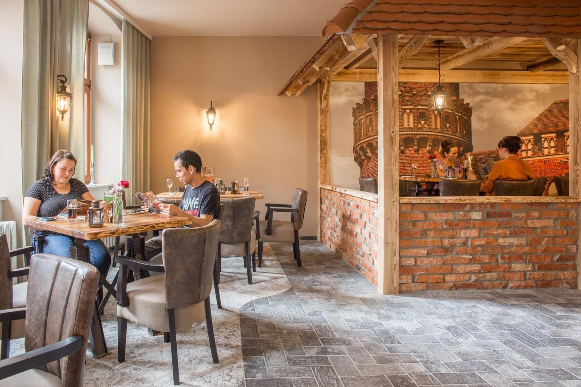 Un restaurante con paredes de ladrillo, vigas de madera y una zona de bar.