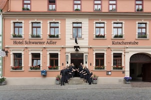 Hotel Schwarzer Adler y Kutscherstube, un grupo de personas en los escalones.
