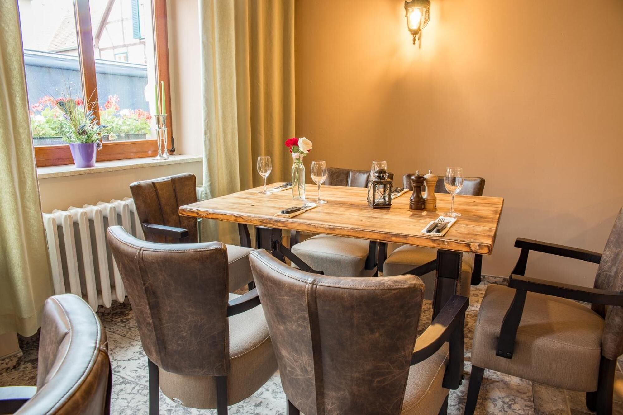 A dining area with a wooden table, six chairs, and a window with curtains.