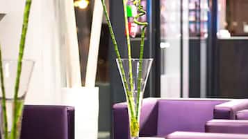 A modern interior with a glass table and purple seating.