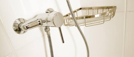 A chrome showerhead with a flexible hose and a metal shower tray.