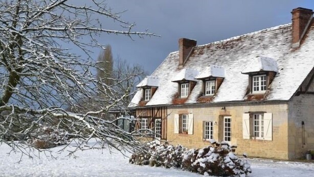 A traditional stone building with multiple windows and a sloped roof covered in snow. - Maison D'hôtes La Bihorée (Saint-Jean-de-Livet)