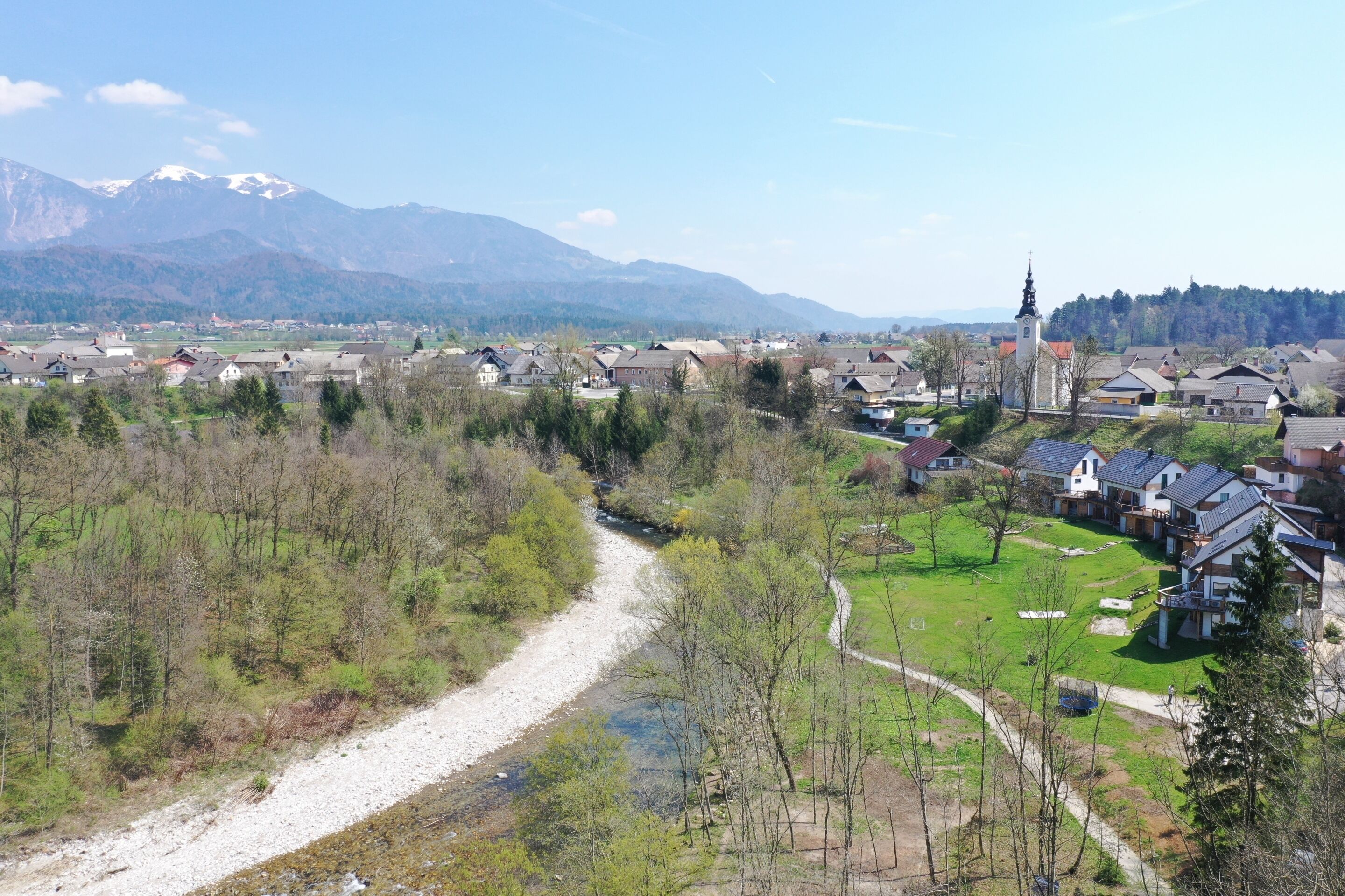 A residential area with houses, a church, and a river.