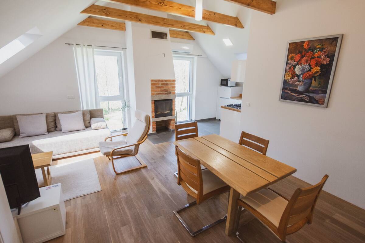 A modern loft apartment with a dining area, kitchen, and living space.
