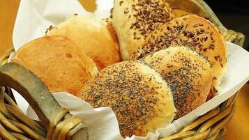 Una cesta con panes variados, incluyendo bollos y panes suaves con semillas.