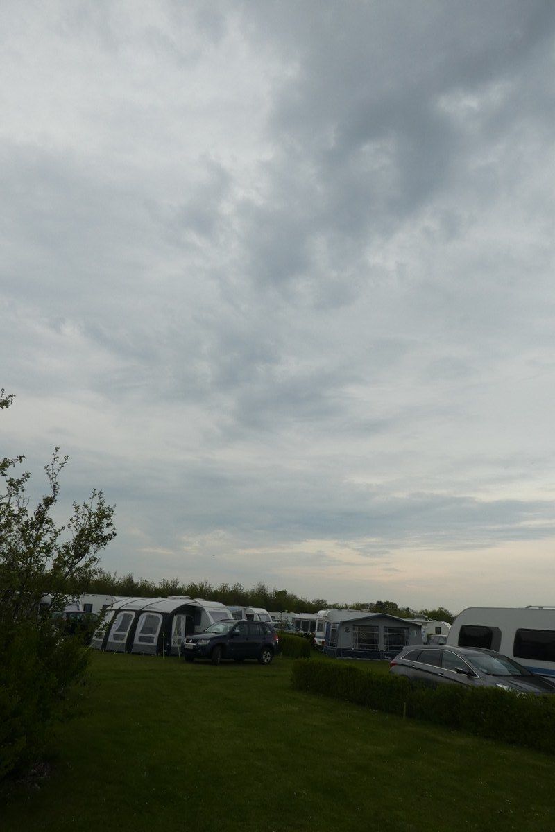 A caravan park with multiple caravans and cars parked.
