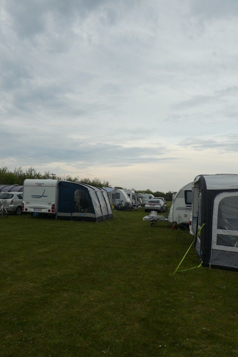 Un parque para caravanas con varias caravanas estacionadas sobre césped.