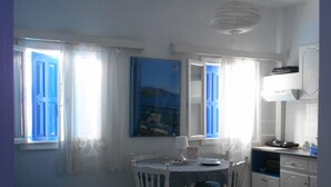 A compact living space with a dining area, a kitchenette, and a seating area with a sofa. - Meltemia Studios Samos (Samos)