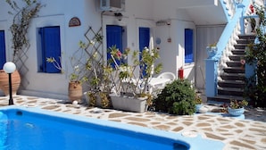 A white building with blue accents, a swimming pool, and a staircase leading to a balcony. - Meltemia Studios Samos (Samos)