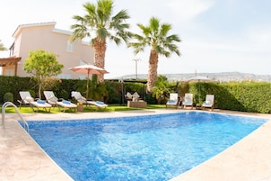 Una piscina al aire libre, sombrillas, tumbonas