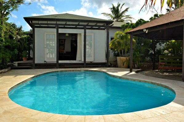 Alberca al aire libre y camastros 