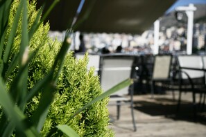 A patio area with outdoor seating and a view of the cityscape in the background. - Demi Hotel (Sarandë)
