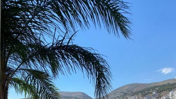 A seaside restaurant with outdoor seating, overlooking a coastal cityscape and the sea. - Demi Hotel (Sarandë)