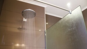 Une douche avec une paroi en verre et un système permettant de voir l'eau couler.
