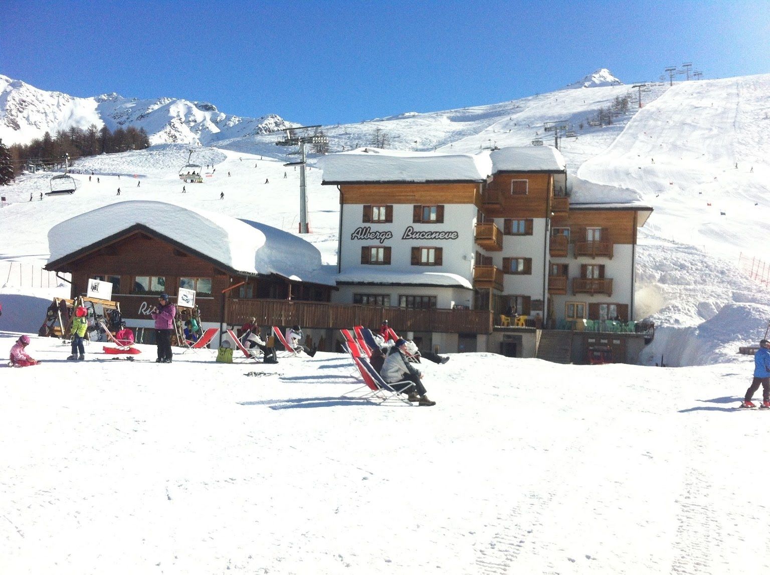 A ski resort building with a sign reading "Albergto Bucanove".