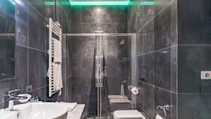 A modern bathroom with a large sink, a glass shower enclosure, and a toilet. - Via Veneto Suites (Rome)