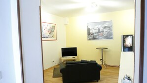 A living room with a black sofa, a TV, a small table, and a framed picture on the wall. - Hotel Samoggia (Valsamoggia)