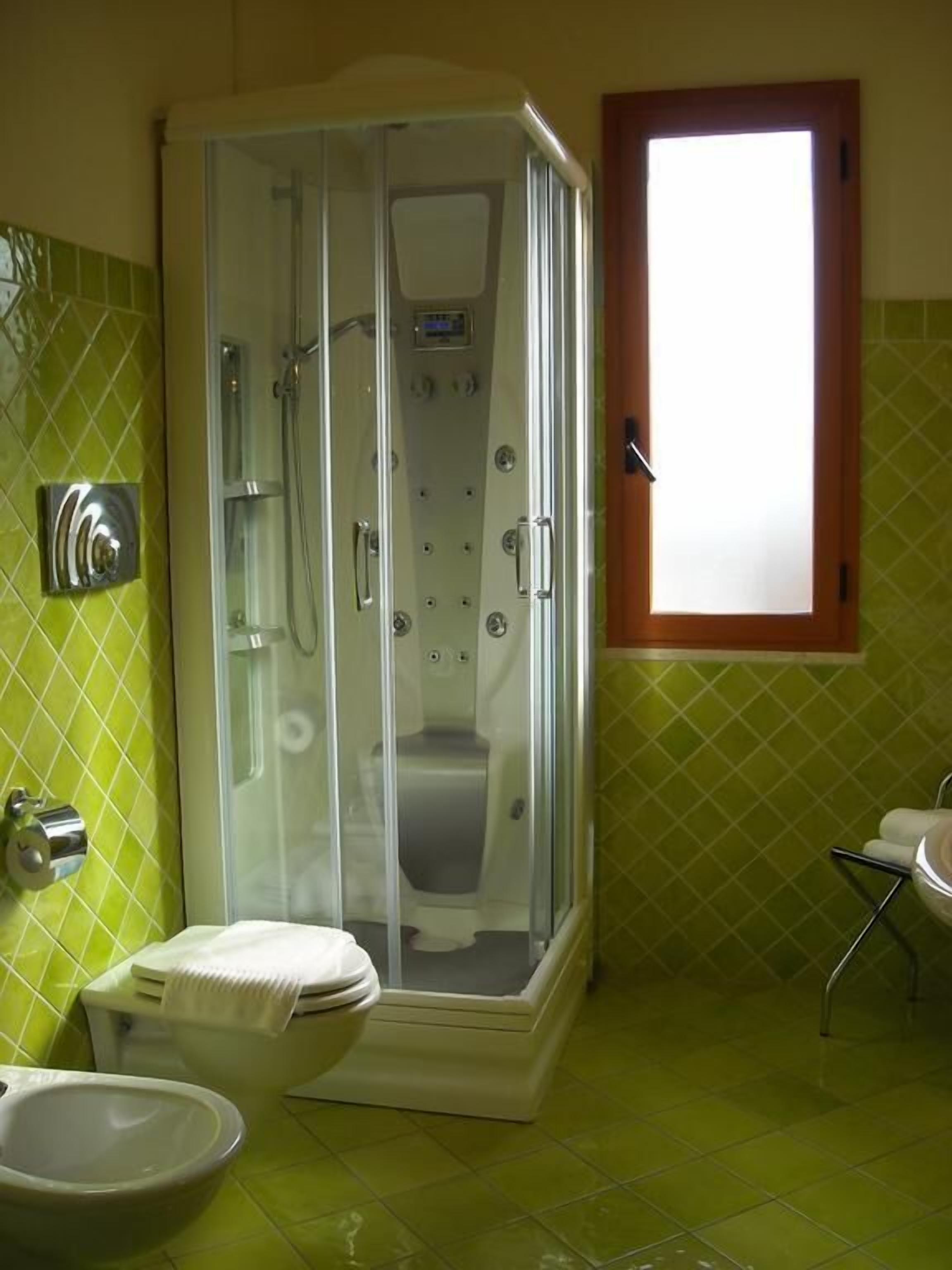 Une salle de bain avec une douche à parois de verre, des toilettes et un lavabo.