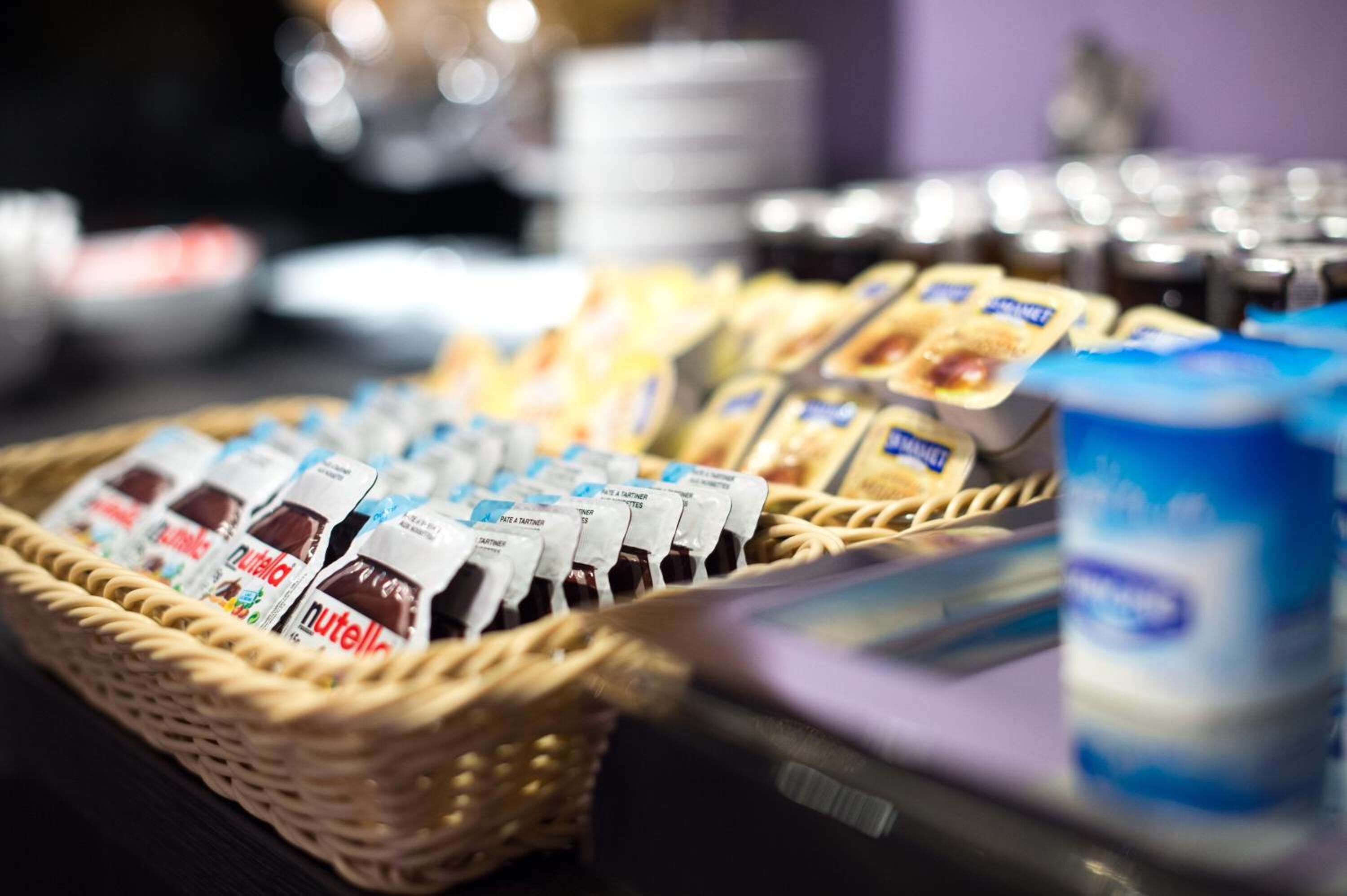 Un bufé con diversas opciones de comida, incluyendo Nutella y otras cremas.