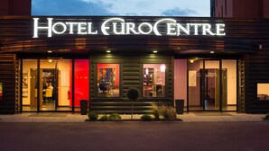 A hotel entrance with a reception area, glass doors, and a small tree in front. - Hôtel Eurocentre Toulouse Nord 3 Stars (Castelnau-d'Estretefonds)