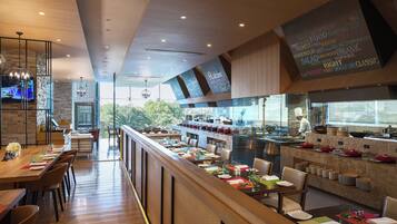 Un restaurant moderne avec un long comptoir, un plancher en bois et un chef qui prépare les plats devant les clients.