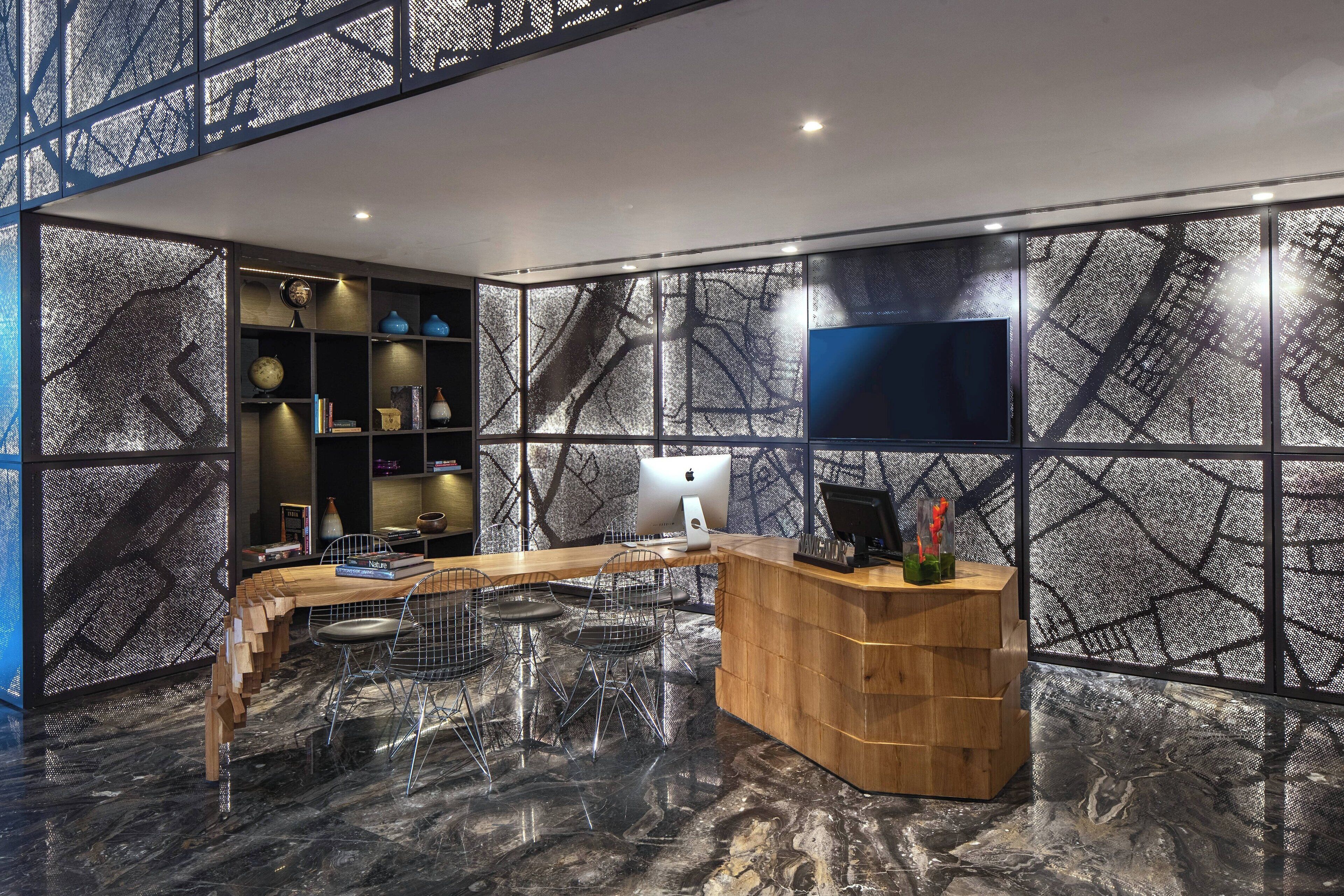 Een modern receptiegedeelte met een houten toonbank, een flatscreen-tv en een behangwand.