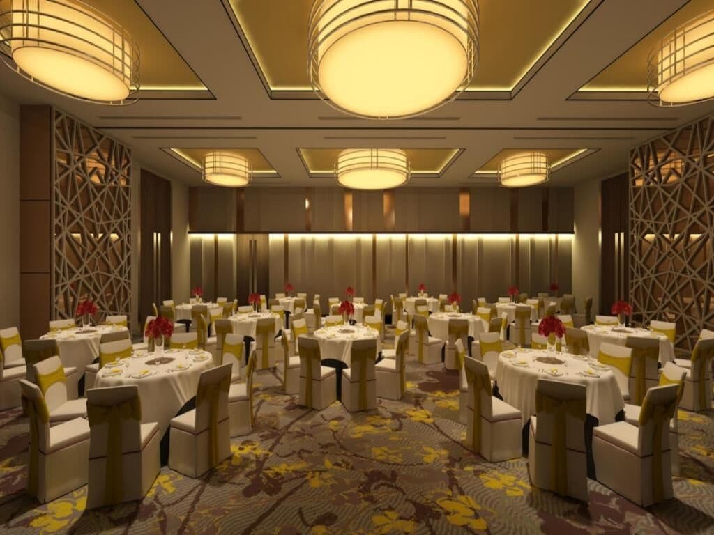 Un salón de banquetes con mesas redondas, sillas y alfombra floral.